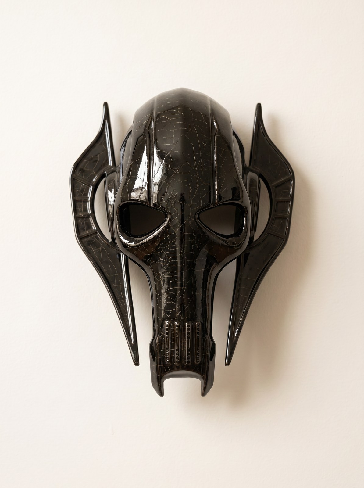 Skull-form ceramic mask in black with gold crackle